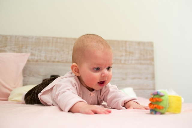 Bebé estica-se para alcançar o brinquedo