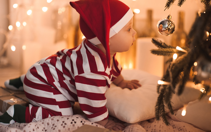 Bebé junto à árvore de Natal